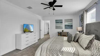 a white bedroom with a bed and a ceiling fan at 2718 Oxymoron in Kissimmee