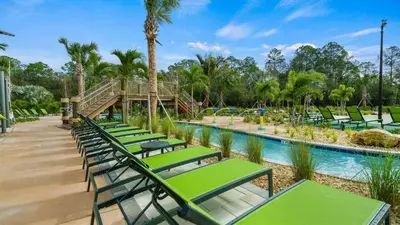 a row of green lounge chairs by a pool at a resort at 4169 Paragraph in Kissimmee
