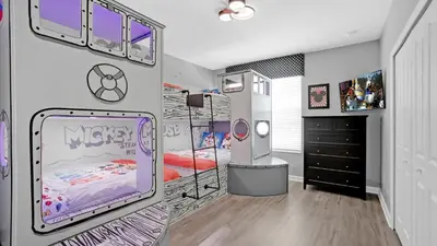 a room with a bedroom with a bed and a dresser at 4277 Prologue in Kissimmee