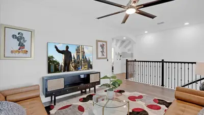 a living room with a tv and a ceiling fan at 4277 Prologue in Kissimmee