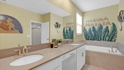 a bathroom with two sinks and a mirror and a tub at 4277 Prologue in Kissimmee