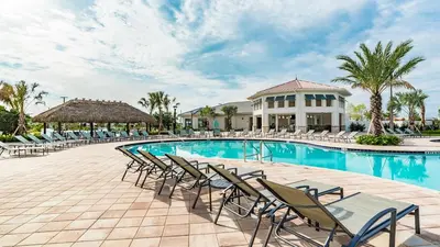 a swimming pool with chairs and a building at 3111 Paradox #202 in Kissimmee