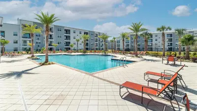 a swimming pool in a resort with palm trees and buildings at 3151 Paradox #102 in Kissimmee