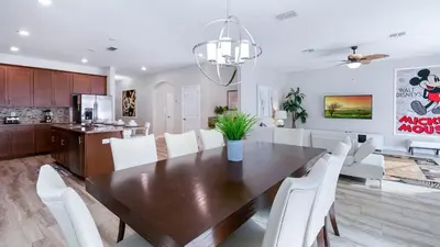 a kitchen and dining room with a wooden table and white chairs at 4720 Sleepy Hollow in Kissimmee