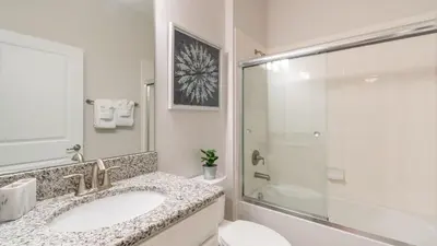 a white bathroom with a sink and a shower at 4724 Sleepy Hollow in Kissimmee