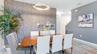 a dining room with a wooden table and white chairs at 4724 Sleepy Hollow in Kissimmee