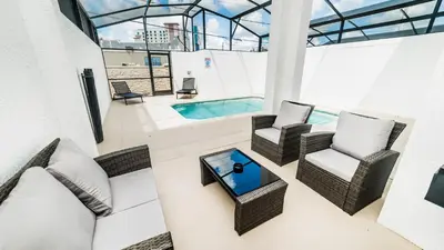 a living room with a couch and chairs and a pool at 4951 Windermere in Kissimmee