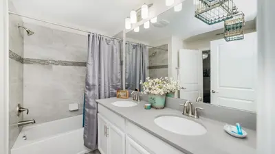 a bathroom with two sinks and a shower and a tub at 4951 Windermere in Kissimmee