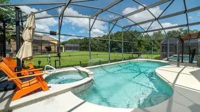 a swimming pool with a chair and an umbrella at 2787 Lido Key in Kissimmee