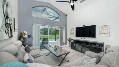 a living room with white furniture and a flat screen tv at 2787 Lido Key in Kissimmee