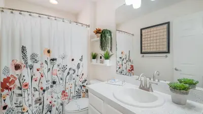 a bathroom with a sink and a shower curtain with flowers at 2787 Lido Key in Kissimmee
