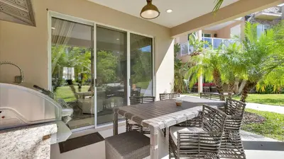 a dining table and chairs on a patio with a sink at 7646 Recife in Kissimmee