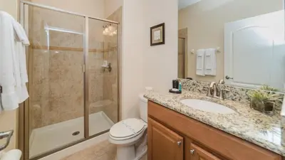 a bathroom with a shower and a sink and a toilet at 8875 Candy Palm in Kissimmee
