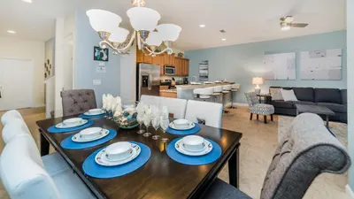 a dining room and living room with a table and chairs at 8875 Candy Palm in Kissimmee