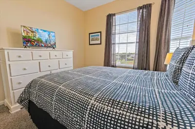 a bedroom with a bed and a dresser and a window at 7654 Comrow #403 in Kissimmee