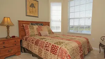 a bedroom with a bed and a lamp and a window at 7660 Comrow #303 in Kissimmee