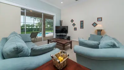 a living room with blue couches and a television at 7705 Comrow in Kissimmee