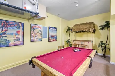 a room with a pool table and posters on the wall at 7719 Comrow in Kissimmee