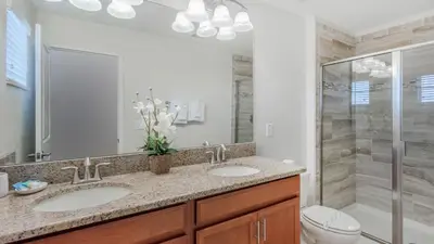 a bathroom with two sinks and a shower at 4741 Kings Castle C in Kissimmee