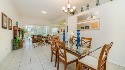 a dining room and living room with a glass table and chairs at 7730 Comrow in Kissimmee
