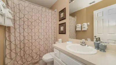 a bathroom with a sink and a toilet and a shower at 7740 Comrow in Kissimmee