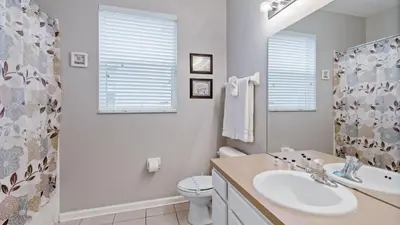 a bathroom with a sink and a toilet and a mirror at 2644 Daulby in Kissimmee