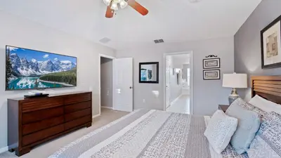 a bedroom with a bed and a tv on the wall at 2644 Daulby in Kissimmee