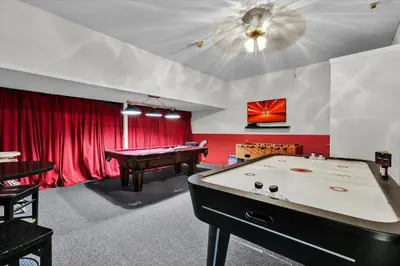 a billiard room with a pool table and red curtains at 7756 Grassendale in Kissimmee