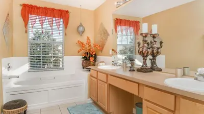 a bathroom with a tub and a sink and a tub and a bath tub at 2696 Manesty in Kissimmee