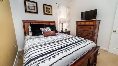 a bedroom with a bed and a dresser with a television at 2696 Manesty in Kissimmee