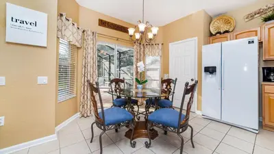 a dining room with a table and chairs and a refrigerator at 2696 Manesty in Kissimmee