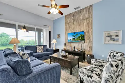 a living room with two blue couches and a table at 2702 Manesty in Kissimmee
