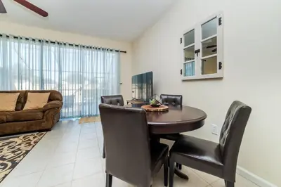a dining room with a table and chairs and a couch at 2505 Maneshaw in Kissimmee