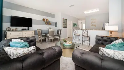 a living room with leather couches and a dining room at 2537 Maneshaw in Kissimmee