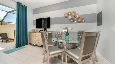 a dining room with a glass table and chairs at 2537 Maneshaw in Kissimmee