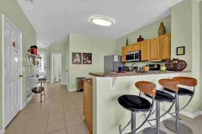 a kitchen with green walls and stools at a counter at 2549 Maneshaw in Kissimmee