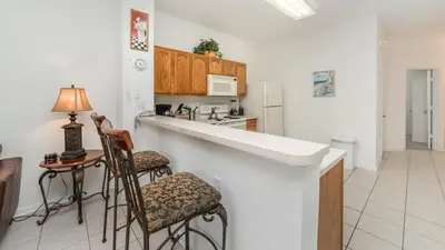 a kitchen with a counter and two bar stools at 7652 Otterspool in Kissimmee