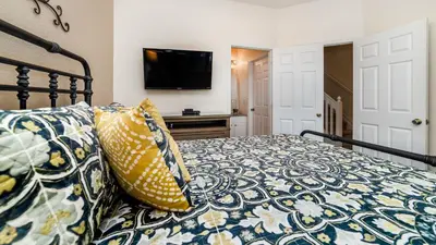 a bedroom with a bed with yellow and blue pillows at 2508 Renshaw in Kissimmee