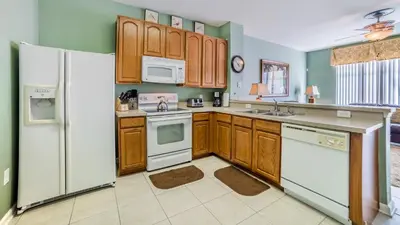 a kitchen with wooden cabinets and white appliances at 2540 Renshaw in Kissimmee