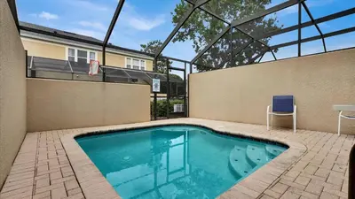 a swimming pool with a chair next to a building at 7653 Sir Kaufmann in Kissimmee