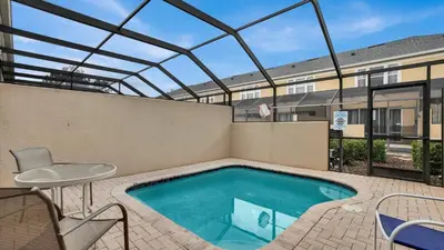 a swimming pool with a table and a chair at 7653 Sir Kaufmann in Kissimmee