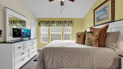 a bedroom with a bed with a dresser and a television at 7653 Sir Kaufmann in Kissimmee