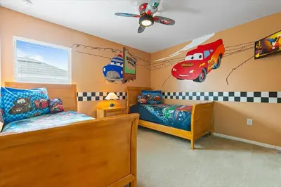 a bedroom with two beds and a car on the wall at 7718 Teascone in Kissimmee