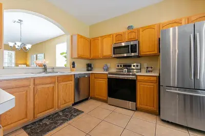 a kitchen with wooden cabinets and a stainless steel refrigerator at 7718 Teascone in Kissimmee