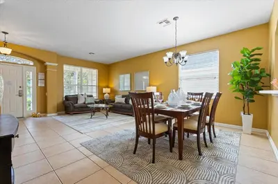 a dining room and living room with a table and chairs at 7718 Teascone in Kissimmee