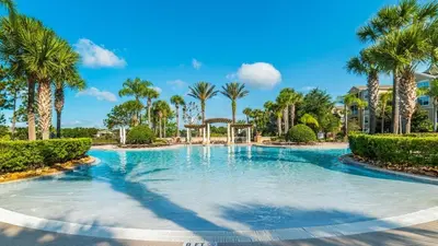 a swimming pool with palm trees in a resort at 7718 Teascone in Kissimmee