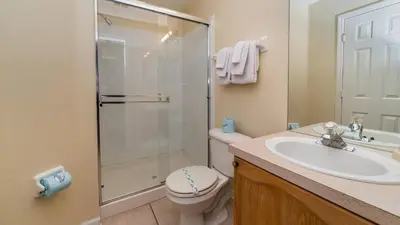 a bathroom with a shower and a toilet and a sink at 8104 Fan Palm in Kissimmee
