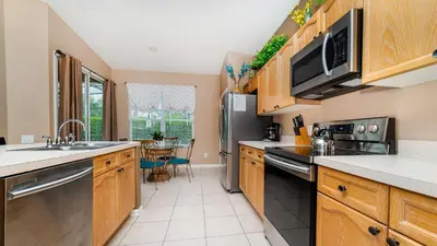 a kitchen with wooden cabinets and a stainless steel refrigerator at 8104 Fan Palm in Kissimmee