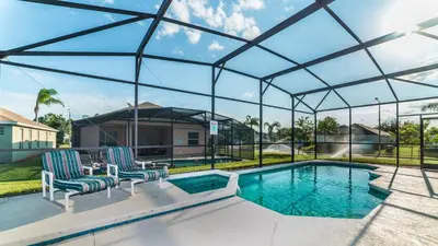 a glass house with a pool and two chairs at 8147 Fan Palm in Kissimmee