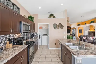 a large kitchen with wooden cabinets and appliances at 8157 Fan Palm in Kissimmee